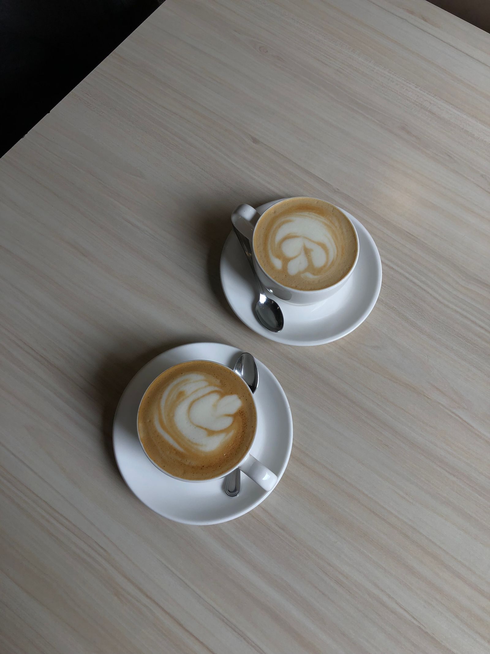 Two cups of coffee on a café table.